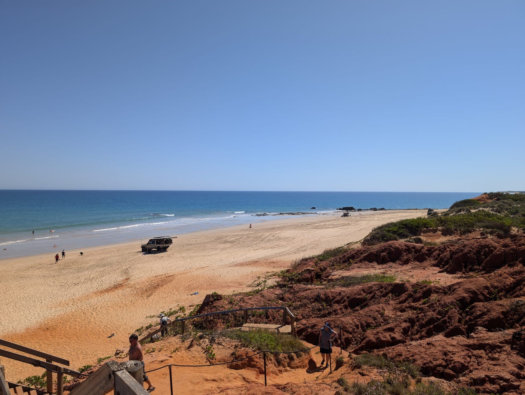 Steps leading down red pindan cliffs to the beach and blue sea at Barn Hill Station